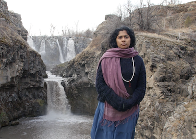 A woman standing in a landscape with waterfalls.