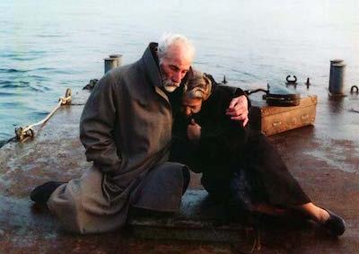A man and woman huddled together on a dock.