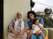 Two women and a baby sitting on a balcony.