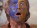 A stunned looking man with paint on his face.