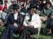 A group of people seated on a lawn.