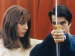 A woman looking at a man who is holding a bow and arrow.