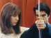 A woman looking at a man holding a bow and arrow.