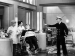 A boat captain pointing at the Marx brothers who are impersonating barbers.