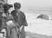 A Japanese woman and man standing by the ocean. 