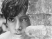 A young boy looking out from behind a wall.