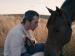 A young man gazing at a horse.