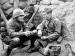 Two military men in a trench.