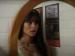 A person with long hair looking in the mirror.