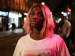 Michaela Coel standing outside at night.