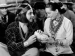 Actors Ramon Novarro and Lupe Velez smiling and sharing bread.