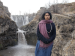 A woman standing in a landscape with waterfalls.