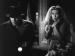 A frightened Joan Blondell wearing a wedding veil next to a man holding a flashlight.