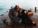 A man and woman huddled together on a dock.